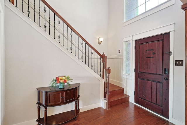 entrance foyer featuring a towering ceiling and dark hardwood / wood-style flooring