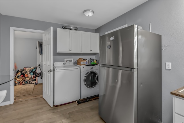 laundry room with light hardwood / wood-style floors and washing machine and clothes dryer