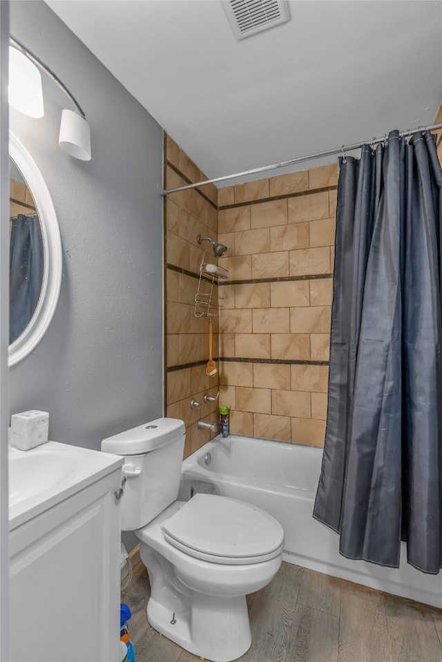 full bathroom with shower / bath combo with shower curtain, hardwood / wood-style floors, vanity, and toilet