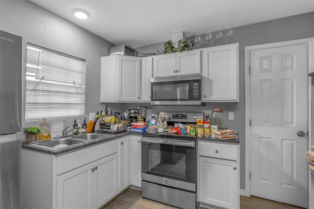 kitchen featuring appliances with stainless steel finishes, sink, and white cabinets