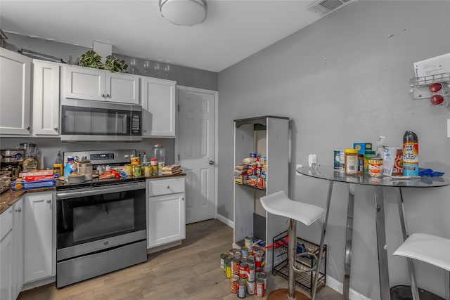 kitchen featuring light hardwood / wood-style floors, white cabinetry, and stainless steel appliances