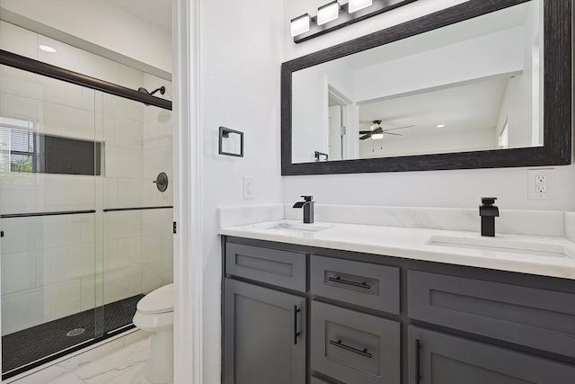 bathroom with ceiling fan, vanity, toilet, and a shower with door