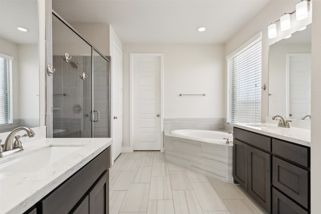 bathroom with vanity, shower with separate bathtub, and a healthy amount of sunlight