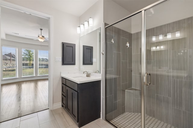 bathroom with wood-type flooring, vanity, ceiling fan, and a shower with shower door