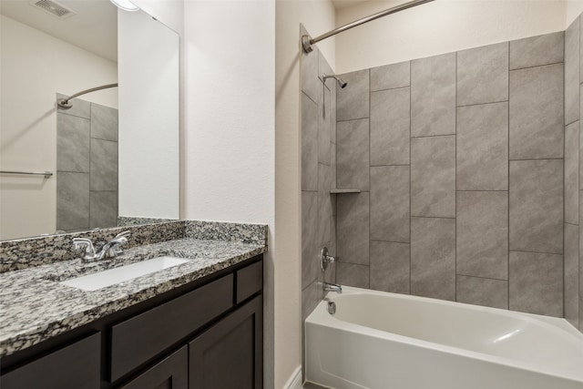 bathroom featuring vanity and tiled shower / bath