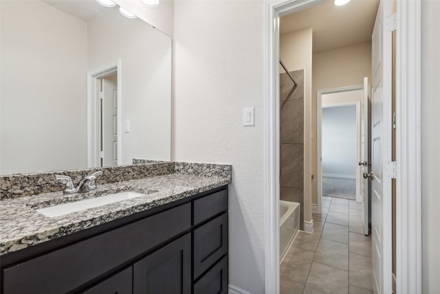 bathroom featuring tiled shower / bath, vanity, and tile patterned floors