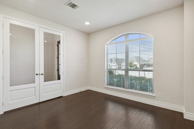 spare room with dark hardwood / wood-style flooring and french doors