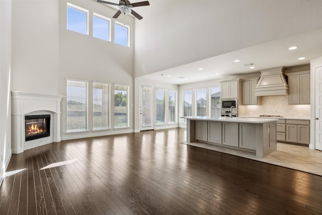3705 Birch Wood Ct, Northlake, TX 76226 - unfurnished living room with ceiling fan, light wood-style flooring, a high ceiling, and a fireplace