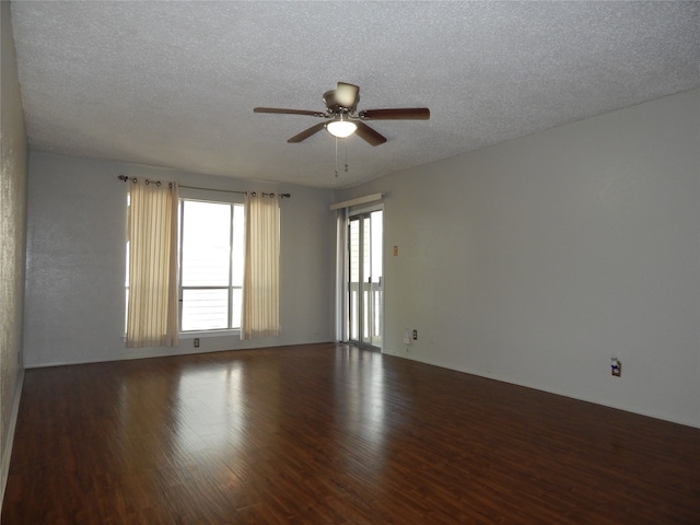 empty room with ceiling fan, a textured ceiling, and dark hardwood / wood-style floors