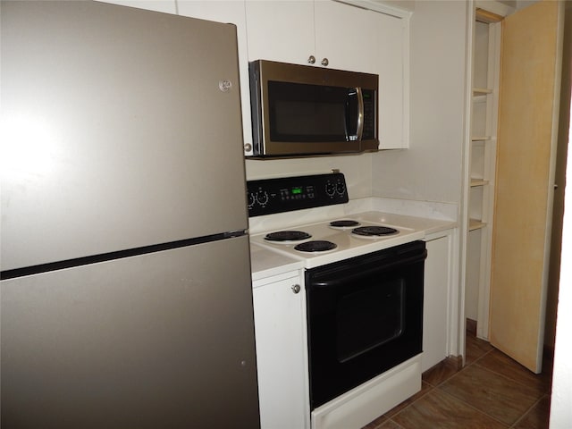 kitchen featuring appliances with stainless steel finishes, white cabinetry, and dark tile patterned flooring