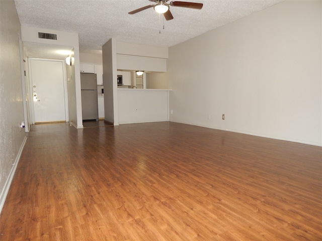 unfurnished living room with wood-type flooring, a textured ceiling, and ceiling fan