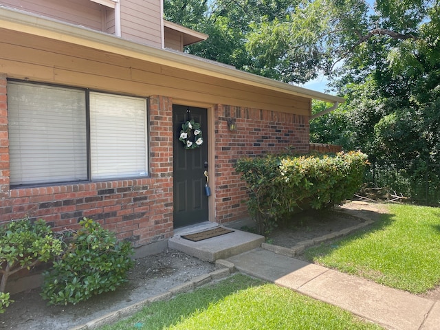 property entrance with a lawn