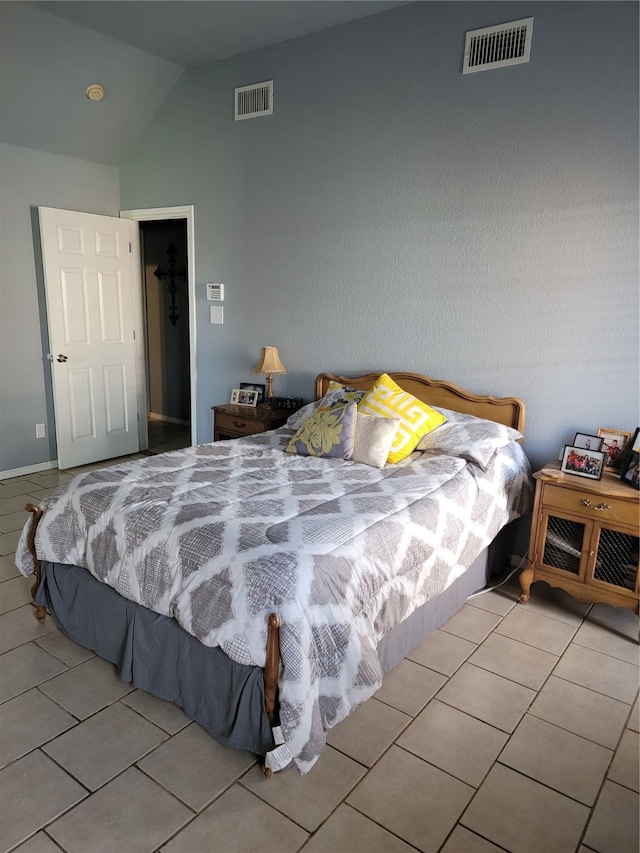 bedroom with light tile patterned floors and vaulted ceiling