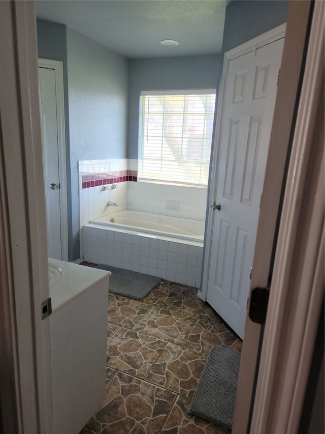 bathroom with a relaxing tiled tub