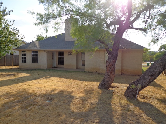 back of property featuring a lawn