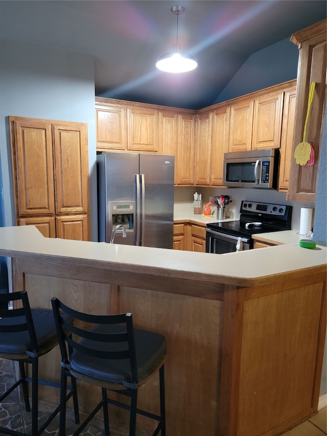 kitchen with stainless steel appliances, kitchen peninsula, a kitchen bar, and lofted ceiling