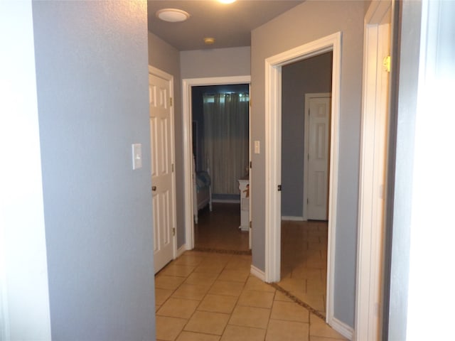 hall with light tile patterned floors