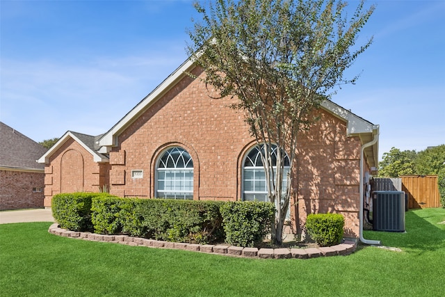 view of side of property featuring a lawn and central AC unit