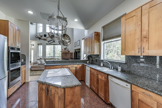 kitchen featuring appliances with stainless steel finishes, a kitchen island, sink, plenty of natural light, and ceiling fan