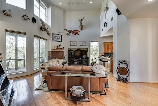 living room featuring ceiling fan, light hardwood / wood-style floors, and plenty of natural light