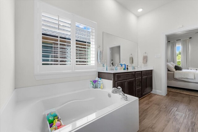 bathroom with vanity, a bathing tub, and hardwood / wood-style floors