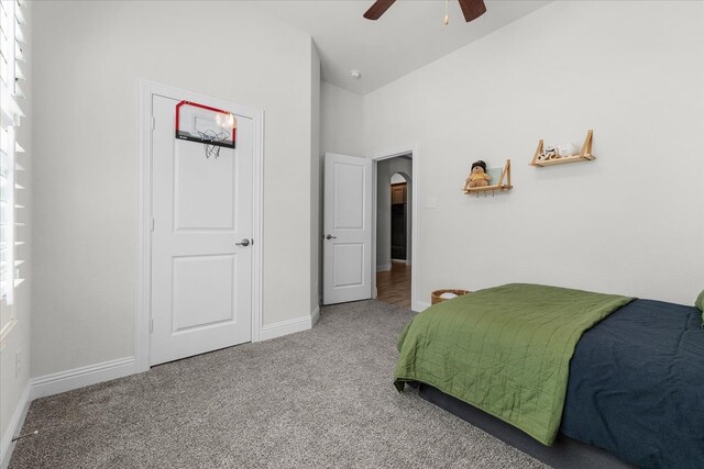 carpeted bedroom with vaulted ceiling and ceiling fan