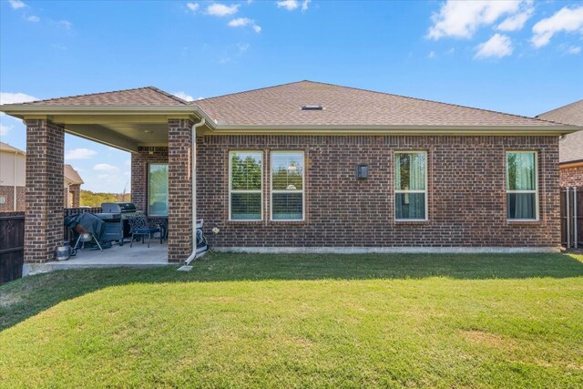 rear view of property with a yard and a patio area