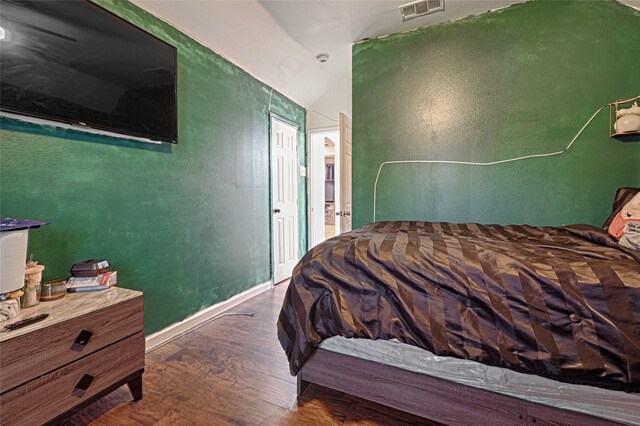 bedroom featuring dark hardwood / wood-style flooring and lofted ceiling