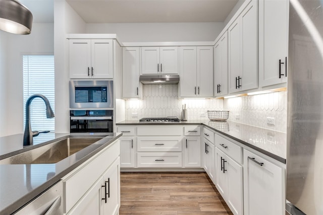 kitchen featuring white cabinetry, sink, and hardwood / wood-style flooring