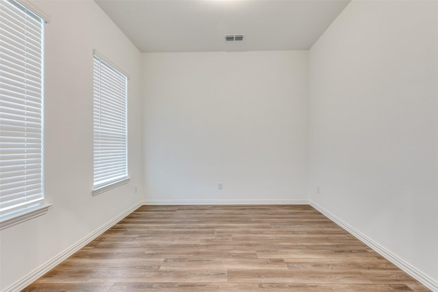 spare room with a wealth of natural light and light hardwood / wood-style flooring