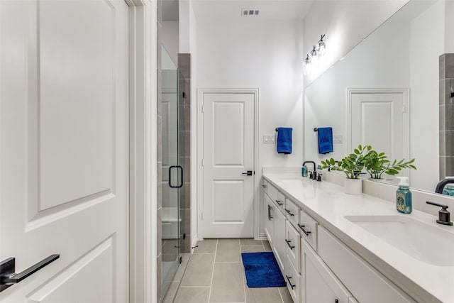 bathroom featuring tile patterned flooring, vanity, and walk in shower