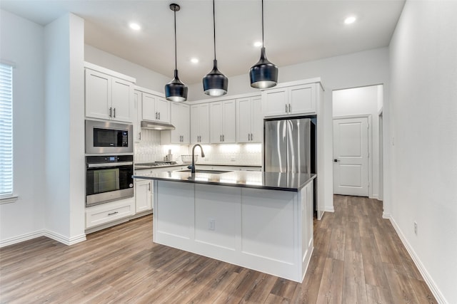 kitchen featuring white cabinets, sink, decorative backsplash, appliances with stainless steel finishes, and wood-type flooring