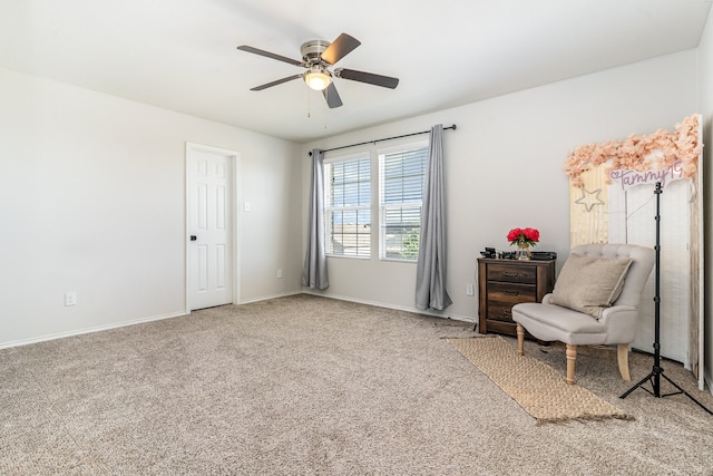 sitting room with ceiling fan and carpet