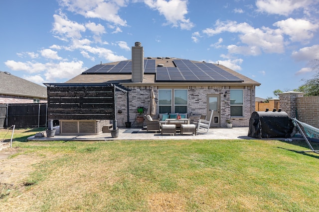 back of house with outdoor lounge area, solar panels, a lawn, and a patio area