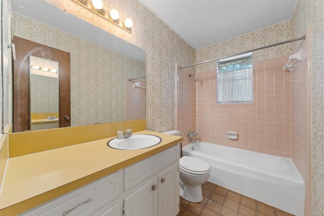 full bathroom featuring vanity, tiled shower / bath combo, toilet, and a textured ceiling