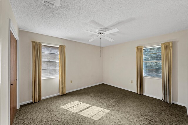 carpeted empty room with ceiling fan and a textured ceiling