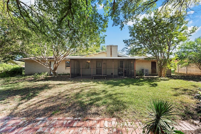 rear view of property with a lawn, a sunroom, and central air condition unit