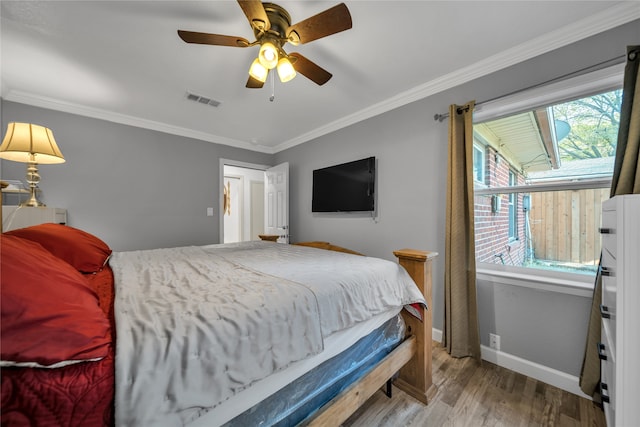 bedroom with crown molding, ceiling fan, and hardwood / wood-style floors