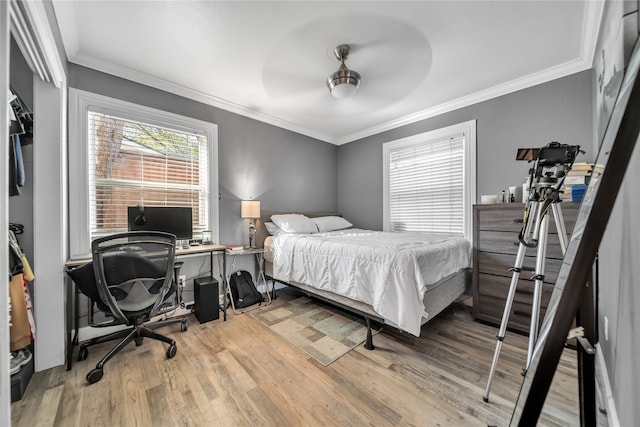 bedroom featuring ceiling fan, crown molding, and hardwood / wood-style floors