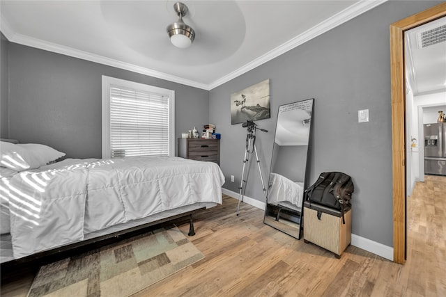 bedroom with crown molding, stainless steel fridge, light wood-type flooring, and ceiling fan