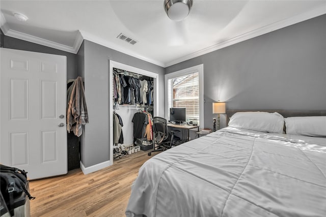 bedroom featuring crown molding, ceiling fan, a closet, and light hardwood / wood-style floors