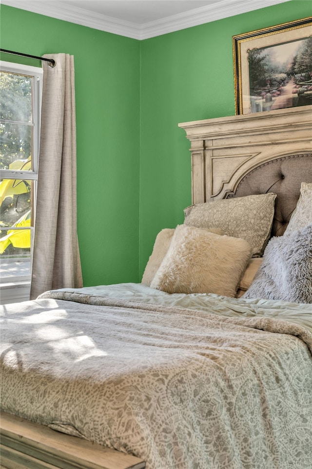 bedroom with ornamental molding and hardwood / wood-style flooring