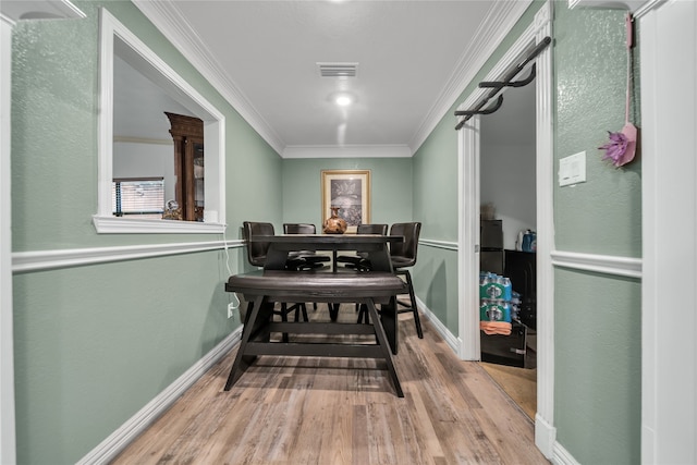 dining area with ornamental molding and wood-type flooring