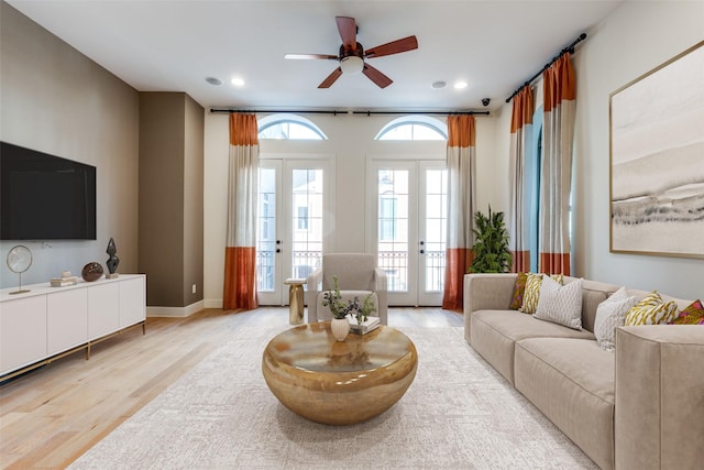 living room featuring light wood-type flooring, ceiling fan, and french doors