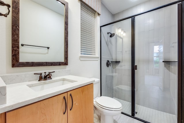 bathroom featuring toilet, a shower with door, and vanity