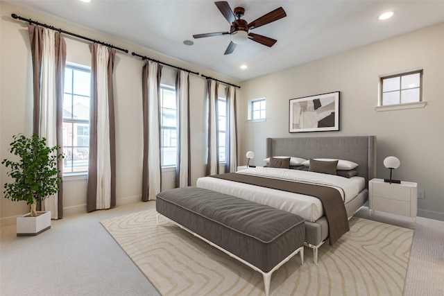 carpeted bedroom featuring ceiling fan and multiple windows