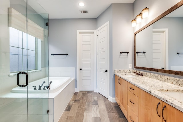 bathroom with vanity, plus walk in shower, and hardwood / wood-style floors