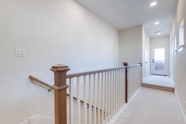 hall with light colored carpet