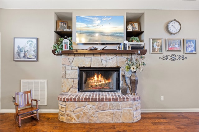 interior space with a stone fireplace and hardwood / wood-style flooring