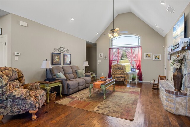 living room featuring dark hardwood / wood-style floors, ceiling fan, a fireplace, and high vaulted ceiling